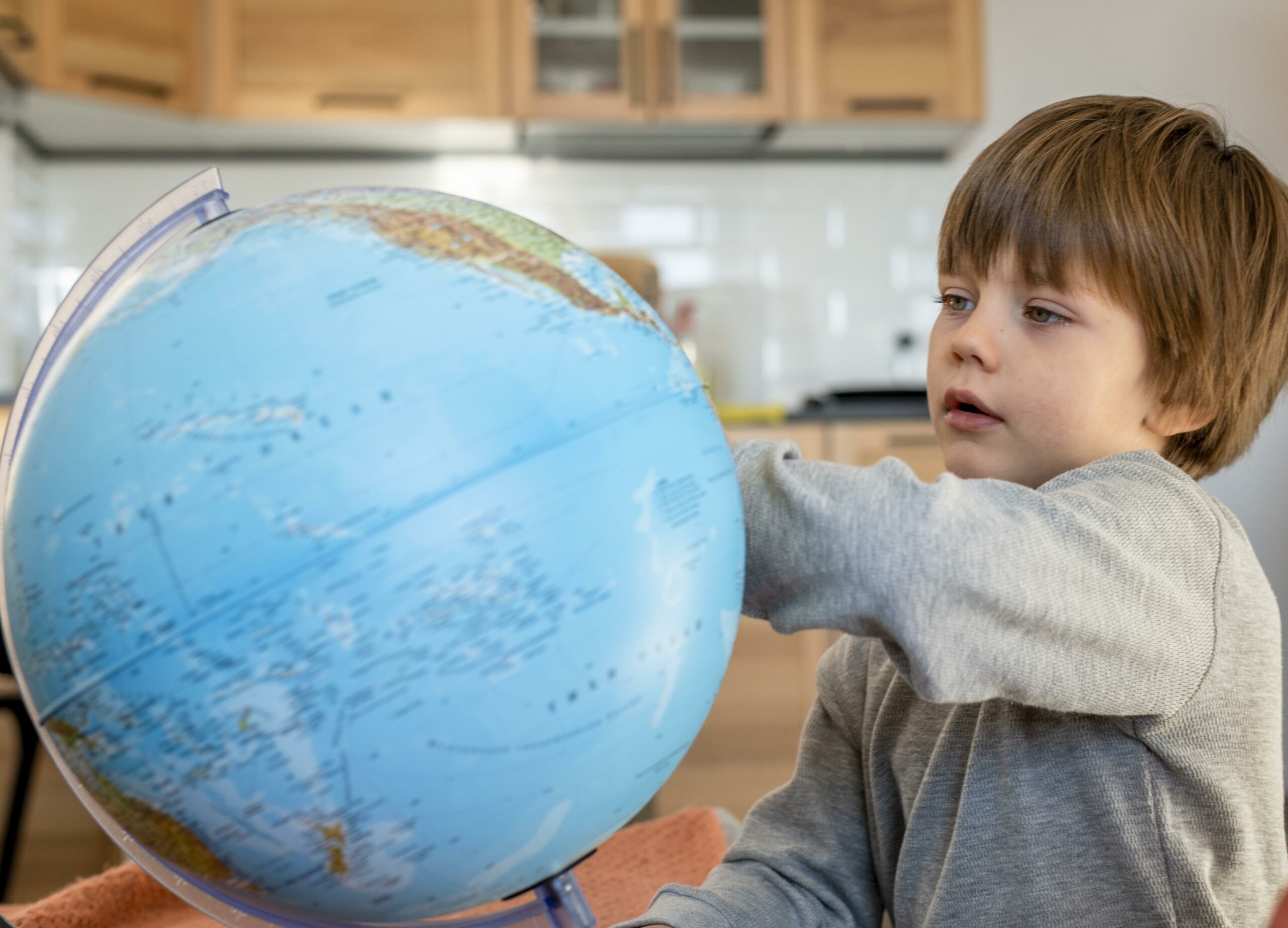 enfant observant un globe terrestre